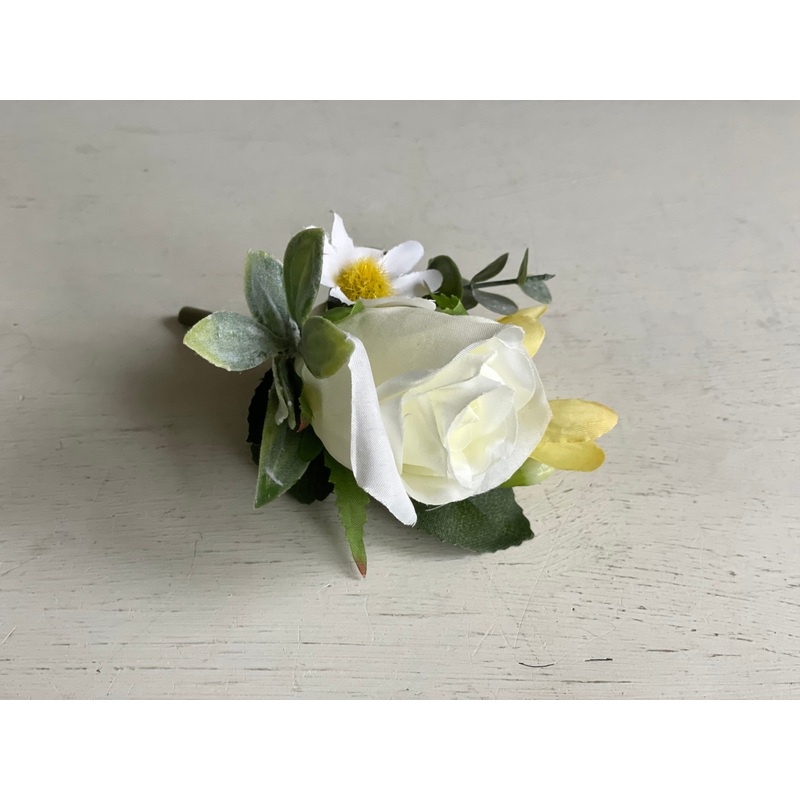 White and yellow wedding buttonhole. Rose, freesia and daisies.